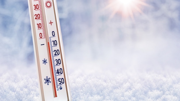 Термометр на зимнем фоне показывает 5 градусов ниже нуля