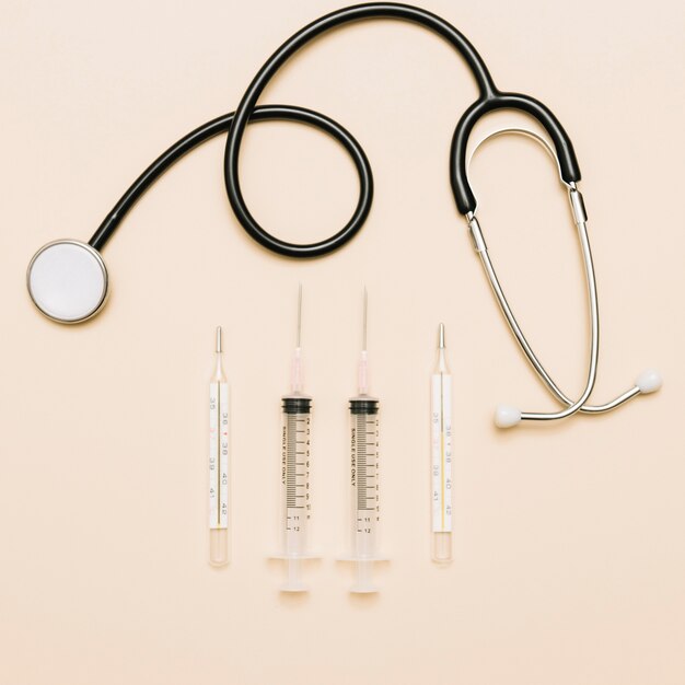 Thermometers and syringes near stethoscope