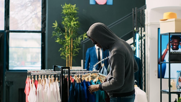 Free photo thief robbing clothing store