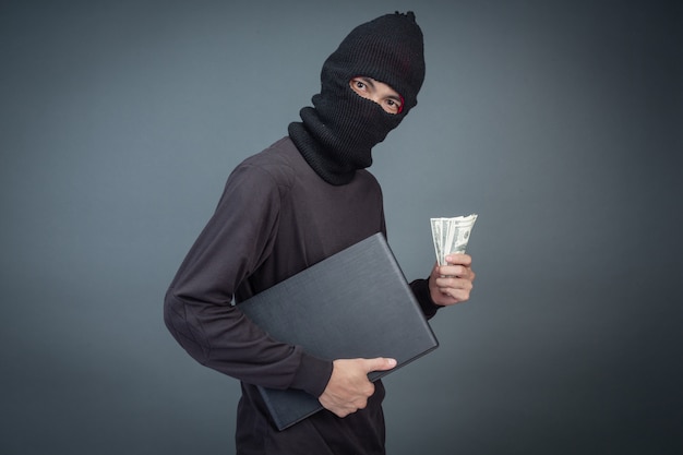 泥棒は、パスワードハッキング活動のためにラップトップコンピューターを使用してクレジットカードを保持しています。