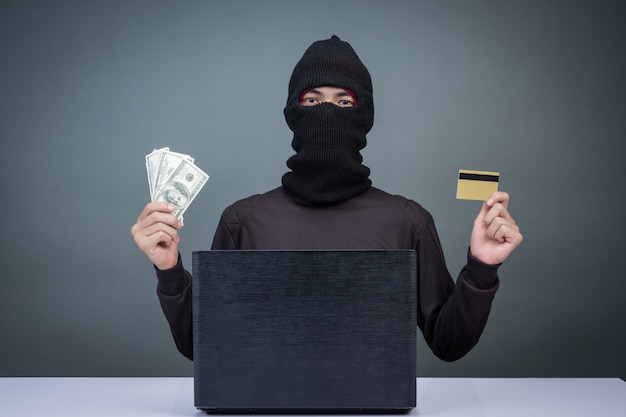 免费照片窃贼持有信用卡，使用笔记本电脑进行密码黑客活动。
