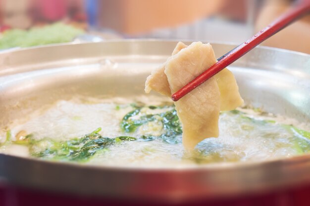 Thin slice pork is put in sukiyaki pot