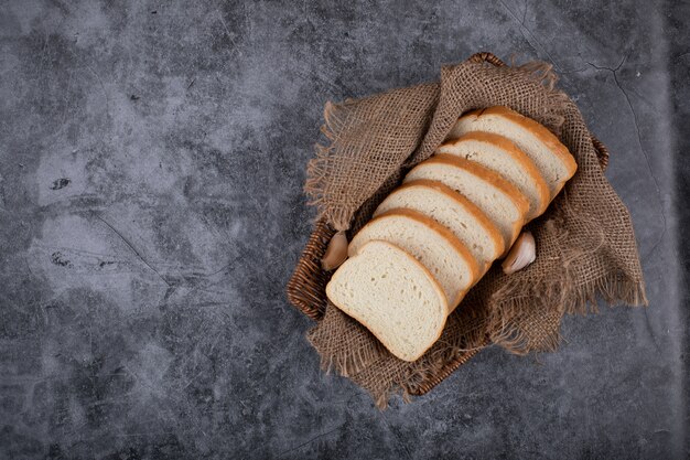 Thin sliced white bread on a piece of burlap.