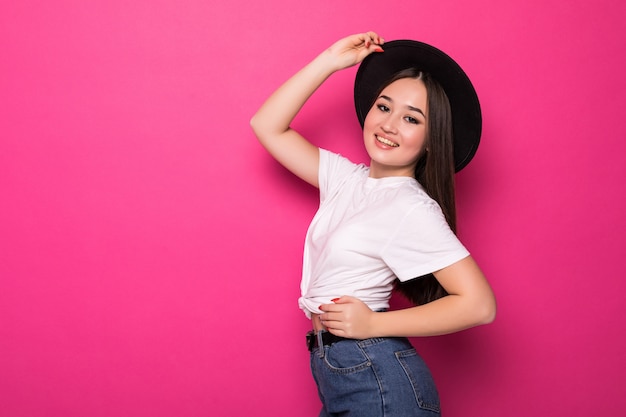 Thinking asian woman happy and joyful on pink wall