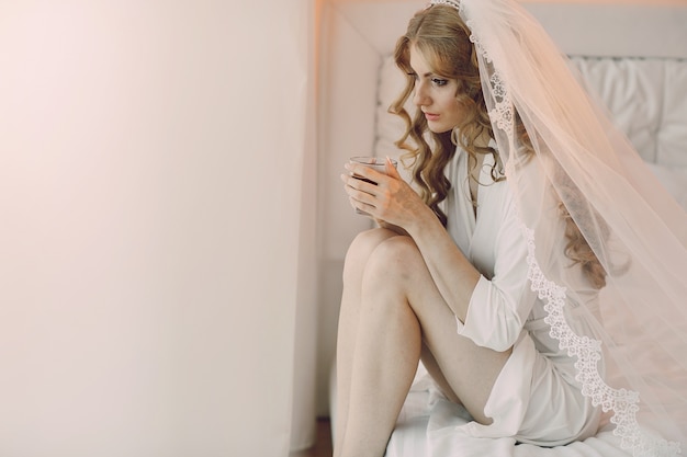 Thinking bride with a cup