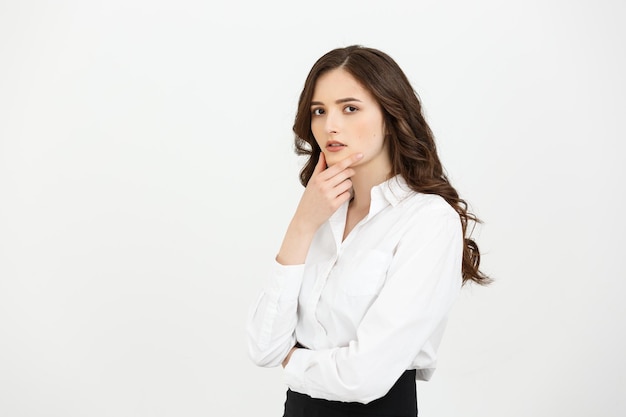 Thinking caucasian business woman with hand on her chin and looking up on grey backgroud