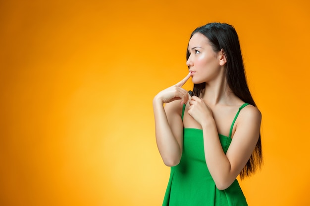 The thinking Chinese girl on yellow background