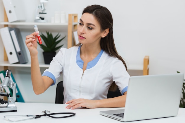 Thinking doctor looking at a blood sample