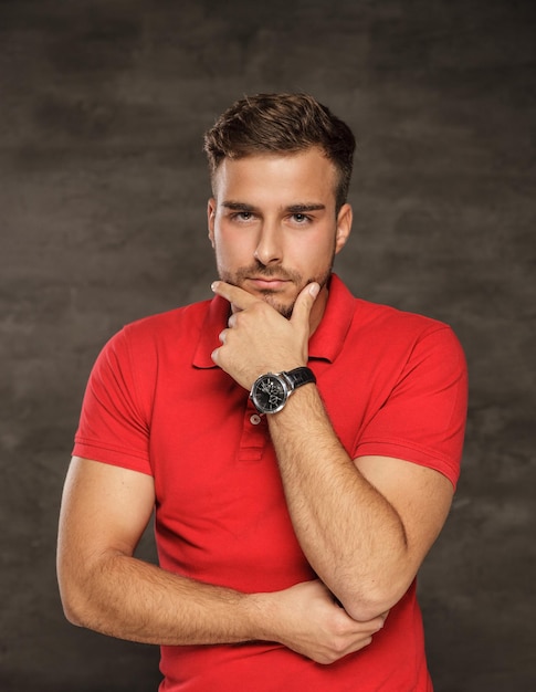 Free photo thinking man in red t shirt. studio shot