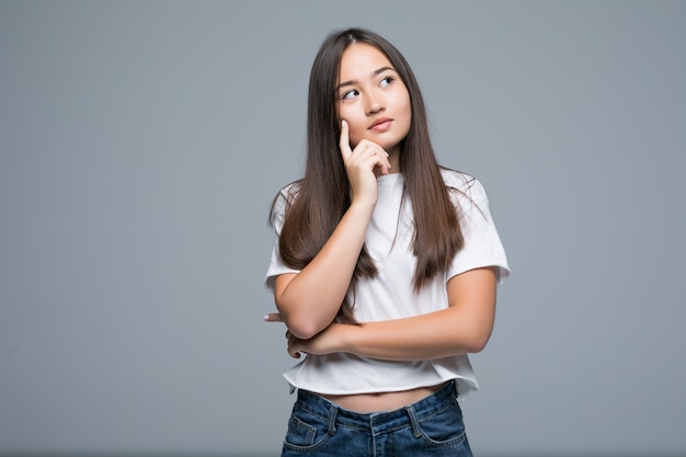 Thinking woman and look copy space isolated on grey background with finger at face, asian beauty