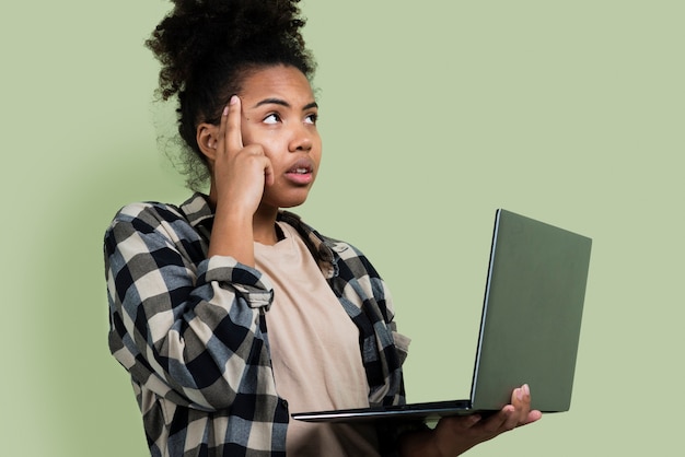 Thinking woman posing with laptop