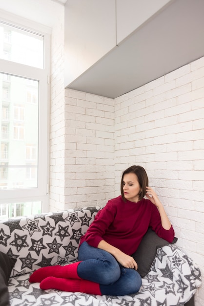 Free photo thinking woman relaxing on sofa