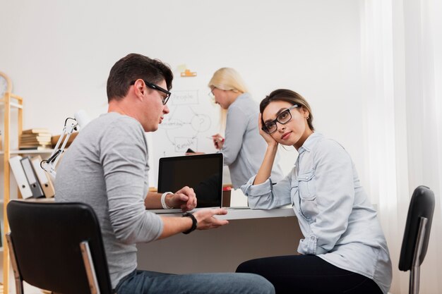 Thinking woman talking with man at office