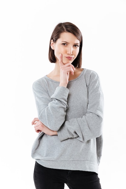 Thinking young caucasian woman standing isolated