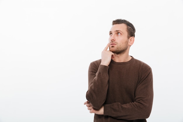 Thinking young man standing isolated