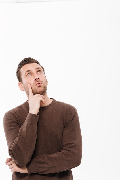 Free photo thinking young man standing isolated