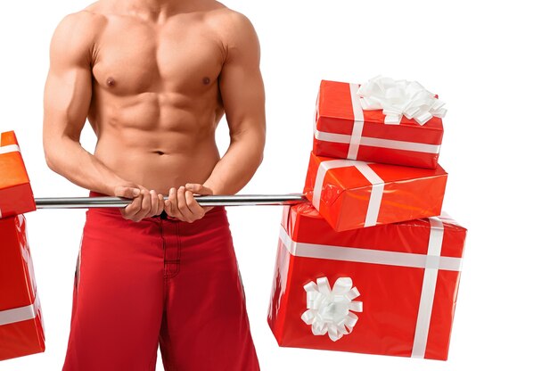 This body is a gift itself. Horizontal closeup shot of a strong muscular man working out with presents in studio isolated on white