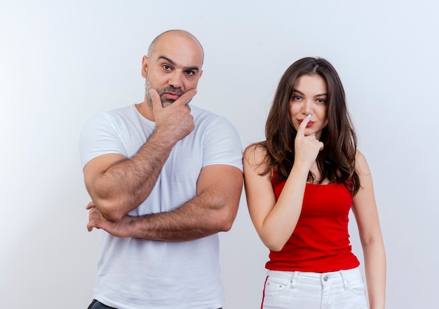 Thoughtful adult couple man touching chin and woman touching lips with finger both looking 