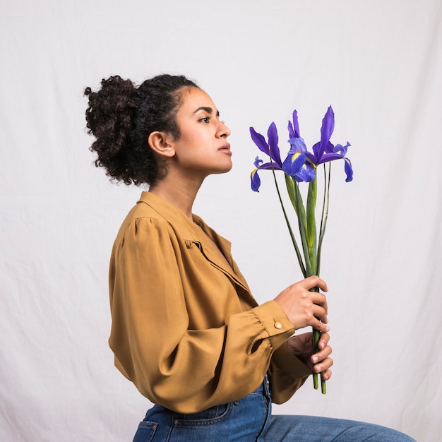 Foto gratuita donna di colore premurosa che tiene fiore blu