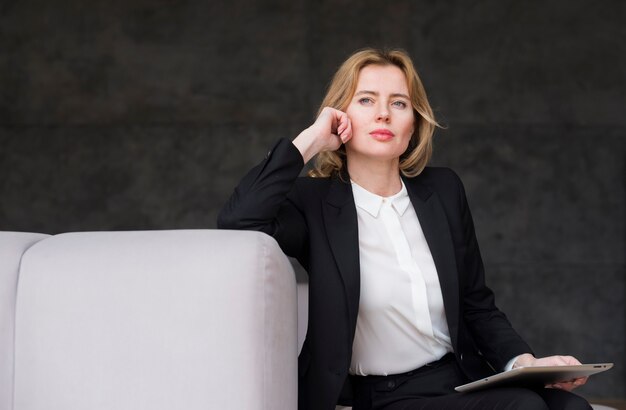 Thoughtful blond business woman with tablet