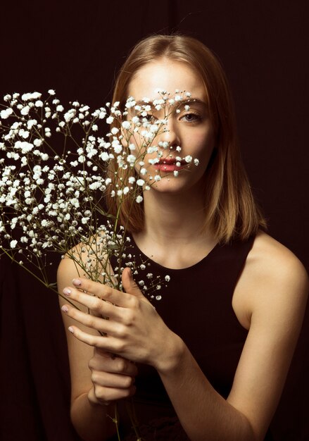 Thoughtful blond woman with white flowers