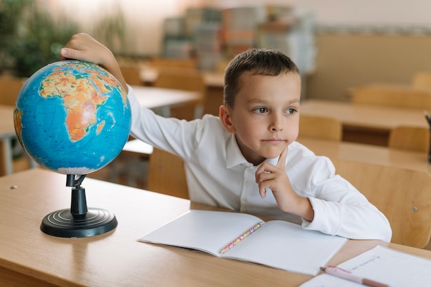 Thoughtful boy with globe