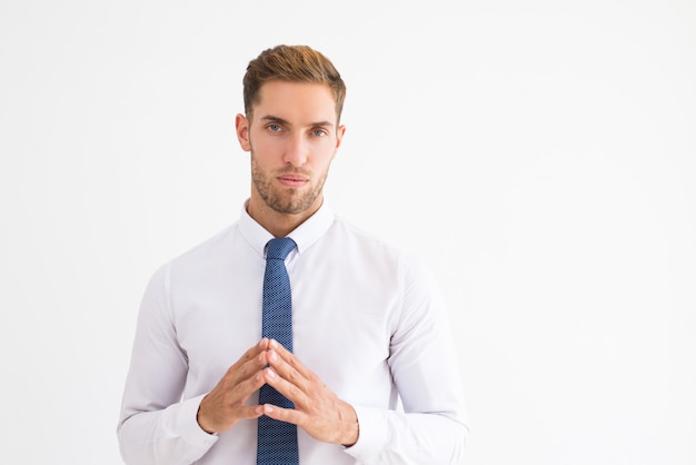 Free photo thoughtful business man holding hands together