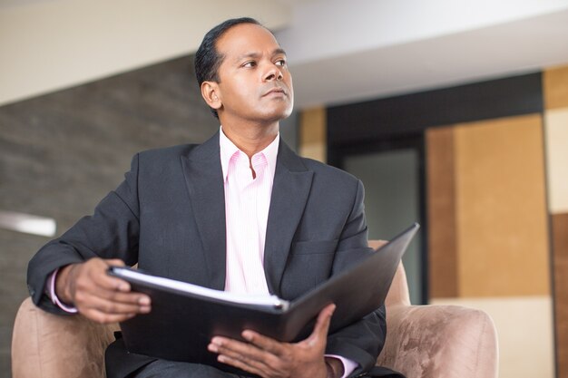 Thoughtful Business Man Reviewing Document