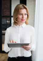 Бесплатное фото Вдумчивый бизнес женщина с помощью планшета