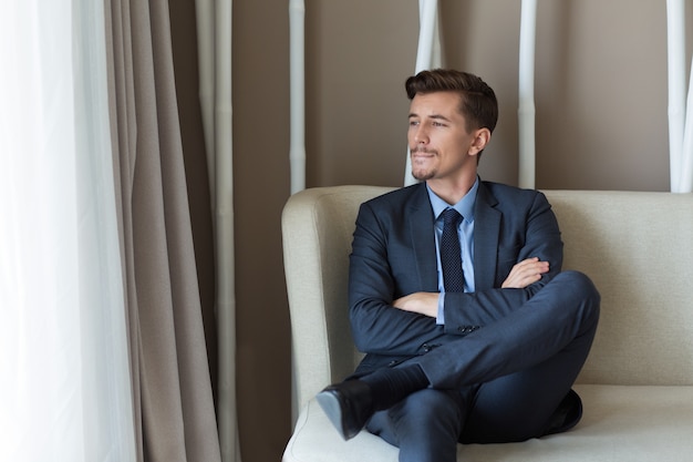 Thoughtful Businessman Sitting in Office Lobby