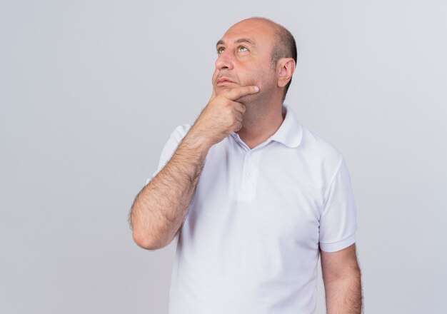 Thoughtful casual mature businessman putting hand on chin and looking up isolated on white background with copy space
