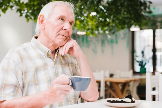 Thoughtful elderly man drinking tea