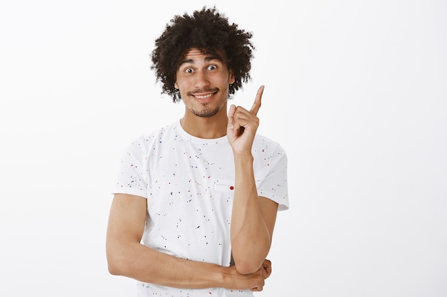 Thoughtful and excited man having an idea, raising finger in eureka gesture