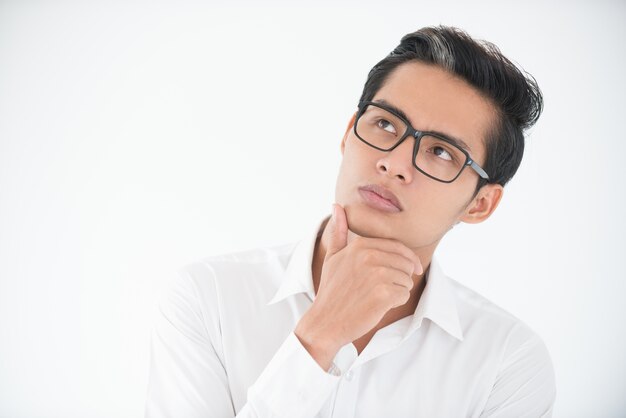 Thoughtful face of young businessman in glasses