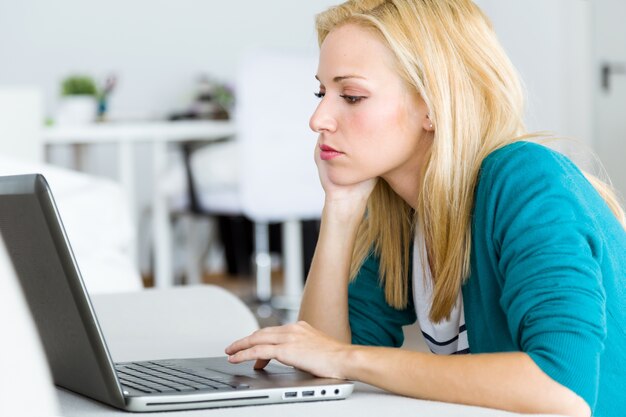 Задумчивый женщина работает на ноутбуке