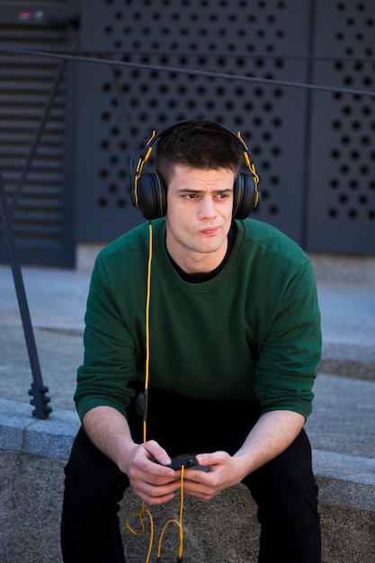 Free photo thoughtful frowning guy with headphones
