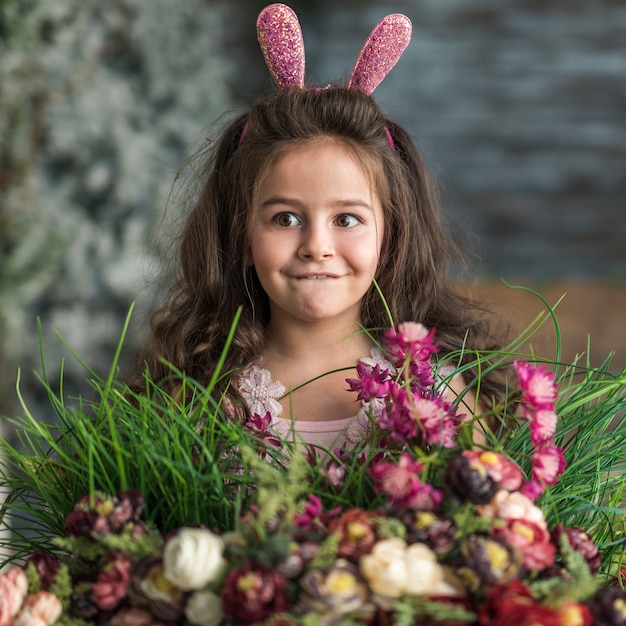 Бесплатное фото Вдумчивая девушка в ушах зайчика с цветами