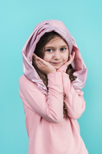 Thoughtful girl standing on blue background 