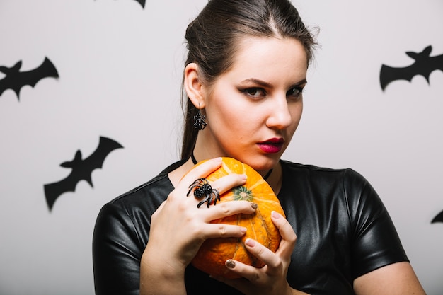 Thoughtful girl with pumpkin