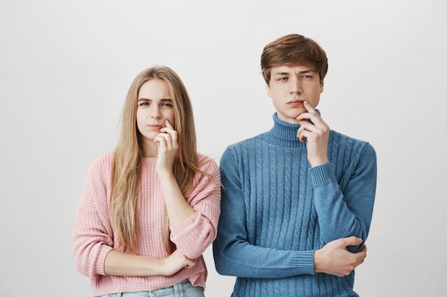 Thoughtful guy and girl thinking. Couple pondering decision