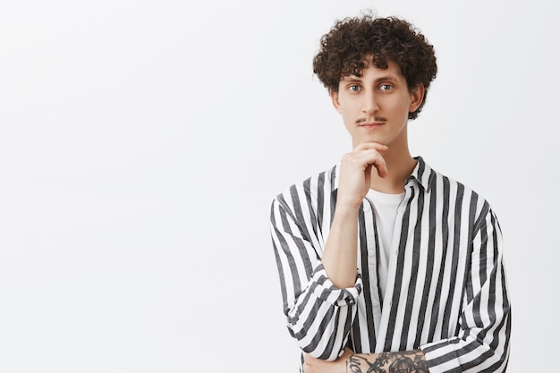 Free photo thoughtful handsome curly-haired guy thinking, pondering decision, making choice