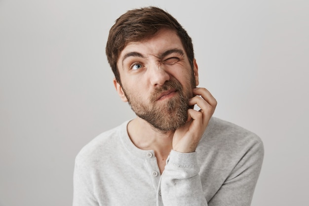 Thoughtful indecisive bearded man scratch beard and looking up thinking