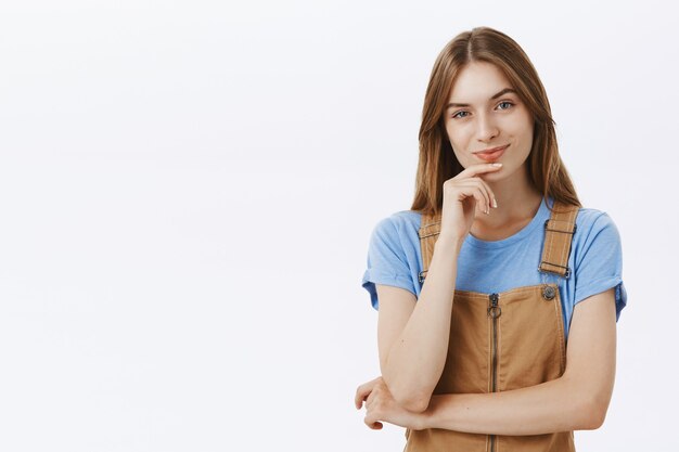 Thoughtful intrigued girl looking coquettish and smiling pleased, made decision