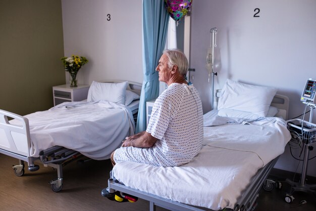 Thoughtful male senior patient sitting in the ward