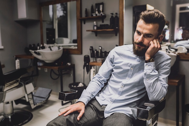 Free photo thoughtful man in barbershop