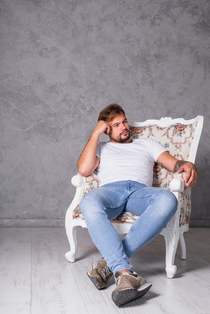 Thoughtful man sitting in armchair 