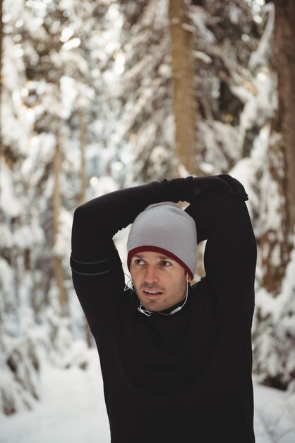 Free photo thoughtful man stretching his hands in forest