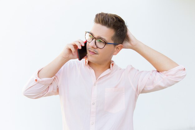 Thoughtful man talking on phone and looking aside