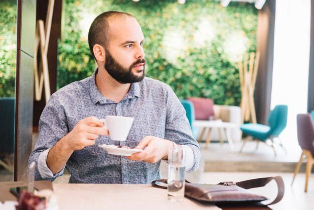 カフェテリアでコーヒーを持つ思いやりのある男