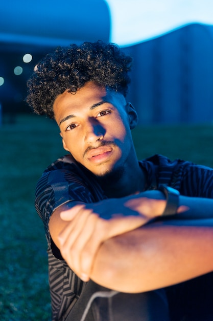 Free photo thoughtful man with folded arms at dusk